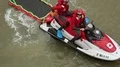Rescuers sitting on water motorcycle with water stretcher behind, first aid HD Footage