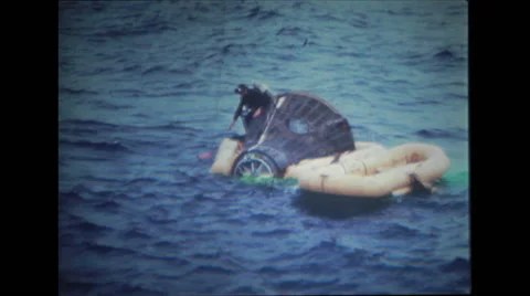Rescuers trying to attach and secure flotation collar to the spacecraft Stock Footage 37596657