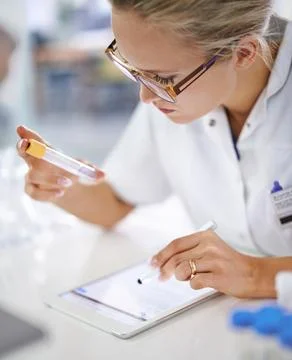 Research and development. A young scientist recording her findings on a tablet. Stock Photos