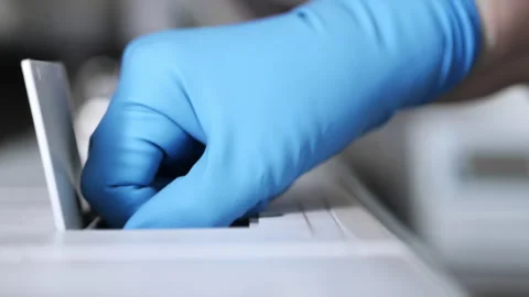 A research assistant puts a sample into a data measuring device. Stock Footage 281701605