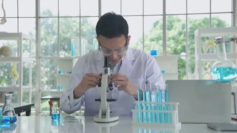 Research concept of 4k resolution. An Asian man dripping liquid into a test.. Stock Footage 246828725
