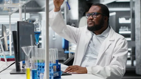 Research facility expert typing on PC keyboard using chemical solutions Stock Footage 320144673