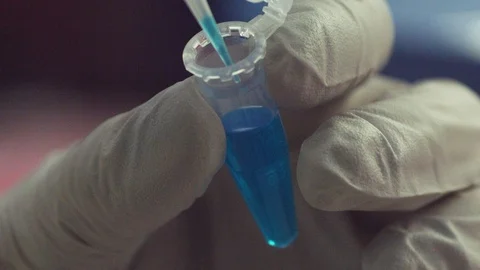 Research Scientist Adding Blue Chemical to Plastic Vial (Slow-Motion) Stock Footage 122862297