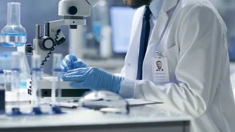 Research Scientist Adjusts Sample in a Petri Dish with Surgical Pincers  Video stock 75406705