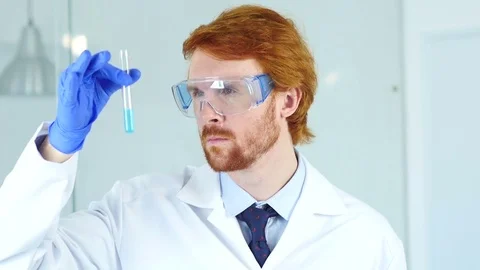 Research Scientist, Doctor Looking at Blue Solution in Test Tube in Laborator Stock Footage 80944701