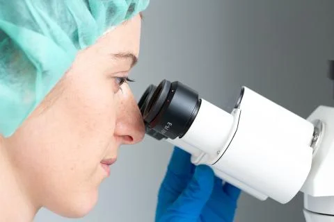 Research scientist examining sample under microscope 스톡 사진