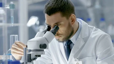 Research Scientist Looks into Microscope. He's Working in a Modern Laboratory. Stock Footage