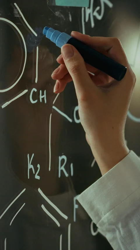 Research specialist writing complex formulas on glass wall in medical facili Stock Footage 331724326
