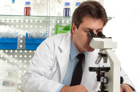 Research under the microscope A researcher observes a substance on a slide... Stock Photos