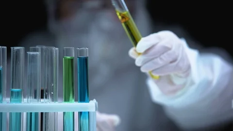 Researcher adding liquid from test tube with fire symbol, warning sign, danger 스톡 동영상 115399759