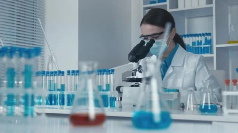 A researcher deeply immersed in the study of the microscopic world works at a Stock Footage 263156595