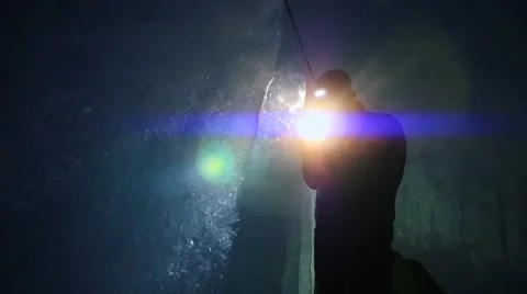 Researcher discovering ice inside glacier cave tunnel holding flashlight Stock Footage 42941835