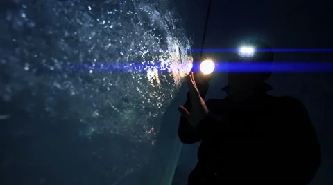 Researcher discovering ice inside glacier cave tunnel holding flashlight Stock Footage 42942792