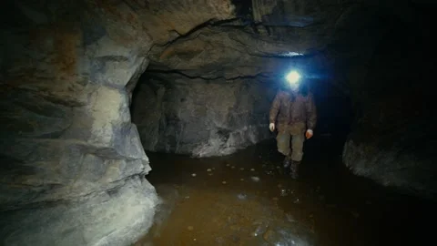 Researcher with a flashlight walking on ice in an abandoned mine Stock Footage 86074607