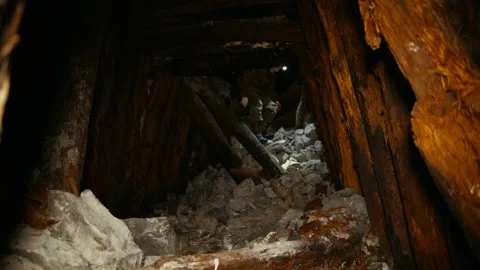 The researcher with a flashlight walks around the collapsing mine Stock Footage 86074972
