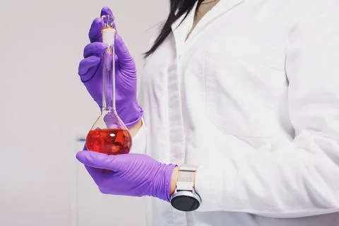 Researcher holds a flask with chemicals and reagents in his hands Stock Photos