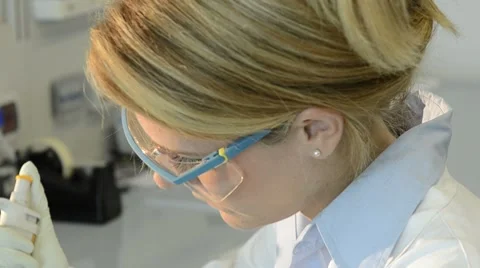Researcher injecting liquid into a microtiter plate Stock Footage 8662575