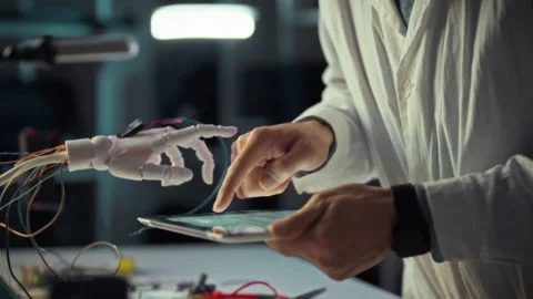 Researcher interacts with robotic hand using a tablet for technology demonst Stock Footage 331357514