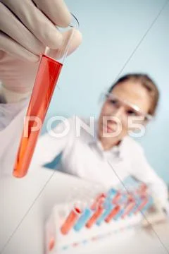 Researcher is looking at beaker tube Stock Photos