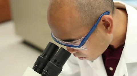 Researcher Looking in Scope with Goggles Stock Footage 9856776