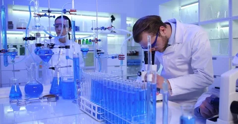 Researcher Man Talking Camera Positive Result on Microscope Teamwork Laboratory Stock Footage 81458482
