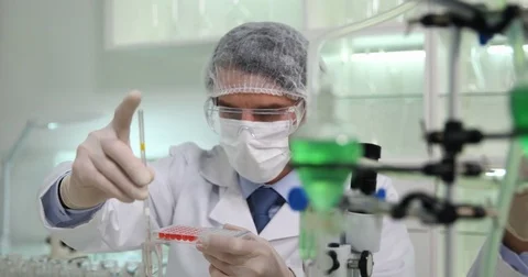 Researcher Men Using Micro Pipette Dropping Solution Laboratory in Micro Plate Stock Footage