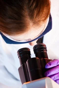 Researcher microscoping. Scientist looking trough the microscope. Copyrigh... Stock Photos