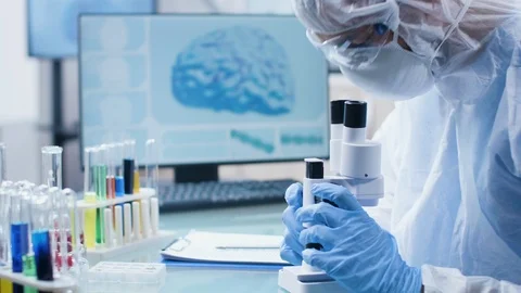 Researcher taking notes in clipboard and looking into the microscope Stock Footage 108736051