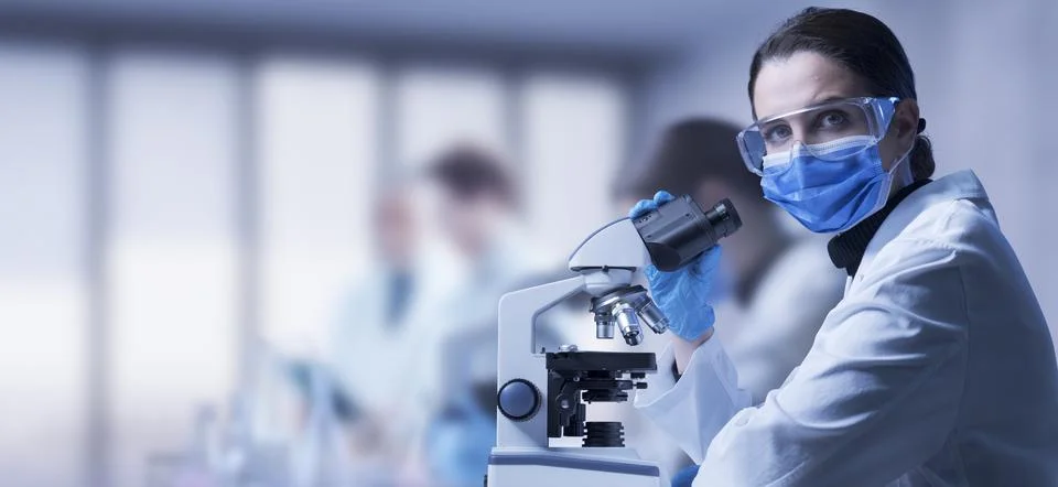 Researcher using a microscope Stock Photos