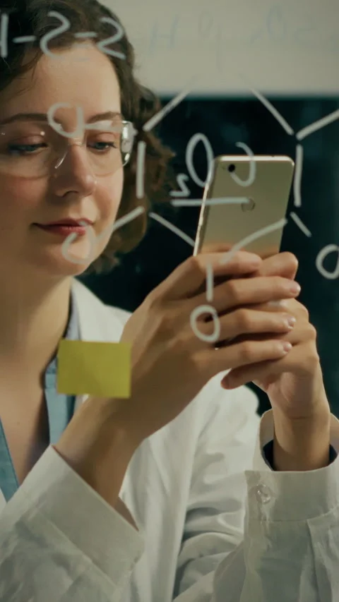 Researcher using smartphone while brainstorming ideas in a laboratory enviro Stock Footage 331724569