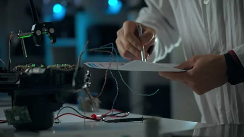 Researcher working on robotics project in laboratory environment with wires Stock Footage 295891972