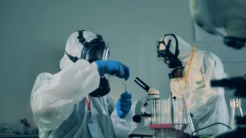 Researchers in hazmats work in laboratory, developing a covid-19 vaccine. Stock Footage 129573503