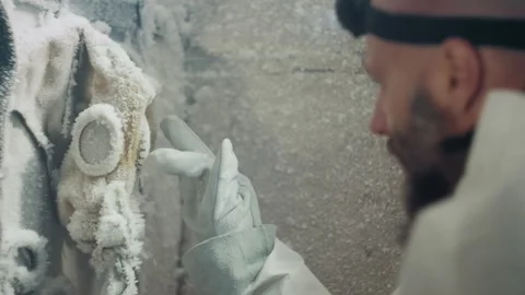 Researching icy mask. Scientist examines frozen gas mask carefully. Scientist Stock Footage 346474476