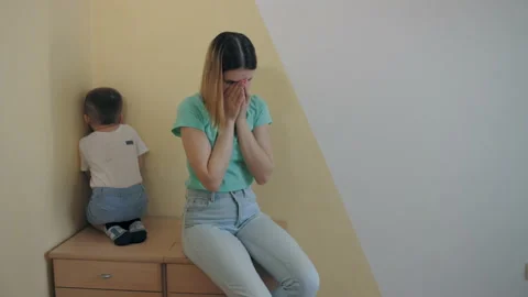 Resentment and quarrel between mom and little son, sit back to back, closes ears Stock Footage 186741343