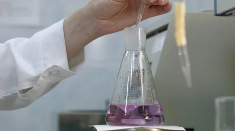 Resercher examining sample and mix magenta liquid Vidéo 52033731