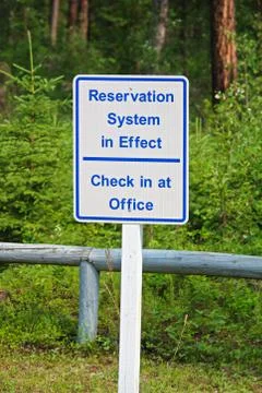 A reservation system in effect sign, check in at office Stock Photos