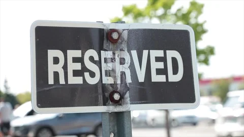 Reserved horizontal rectangle black white sign on metal post with parking lot Stock Footage 251365261