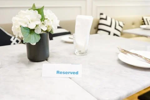Reserved plate on a dinner table in a restaurant with elegant table setting Stock Photos