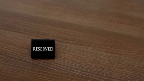 Reserved sign on the table. A tag of reservation placed on the wood table. Stock Footage 155214913