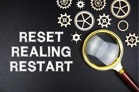 Reset Realing Restart text message with magnifying glass on black background Stock Photos
