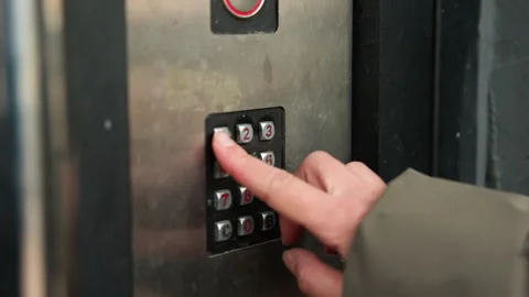 Resident inputs code in dim entrance. Nighttime building access process showing Stock Footage 346244690
