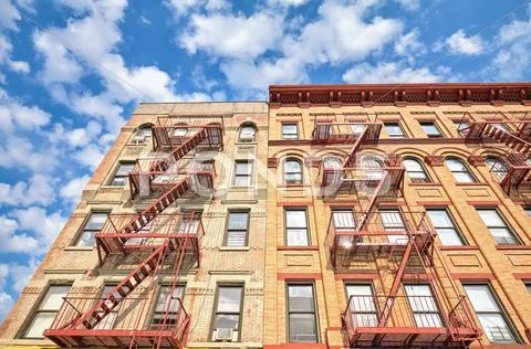 Residential building with fire escape ladders in NYC. Stock Photos