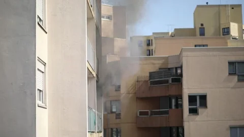 Residential building on fire, flames and smoke breaking out from the window. Stock Footage 316601729
