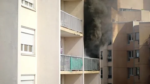 Residential building on fire, flames and smoke breaking out from the window. Stock Footage 316601739