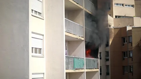 Residential building on fire, flames and smoke breaking out from the window. Stock Footage 316601745