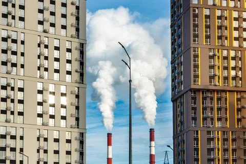 Residential buildings located  close to the steaming pipes of thermal power p Stock Photos