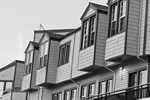 Residential complex with multiple stories and large windows under clear sky Stock Photos
