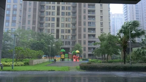 Residential compound playground during heavy wind?driven rain, wet pavement Vidéo 344828608