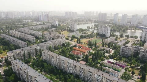 Residential courtyards with green trees around and skyscrapers in the background Stock Footage 156957341
