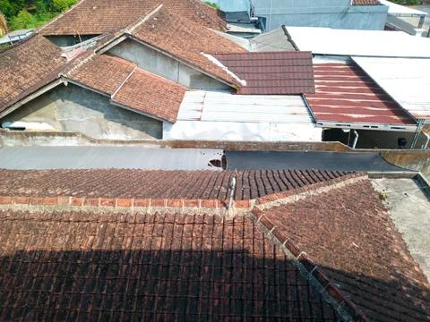 Residential Rooftops With Mixed Roofing Materials In Urban Neighborhood Stock Photos